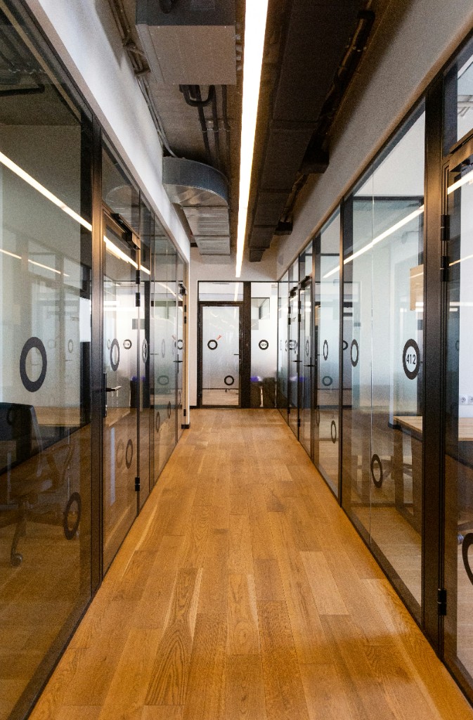Corridor lined with glass partitions and linear ceiling light