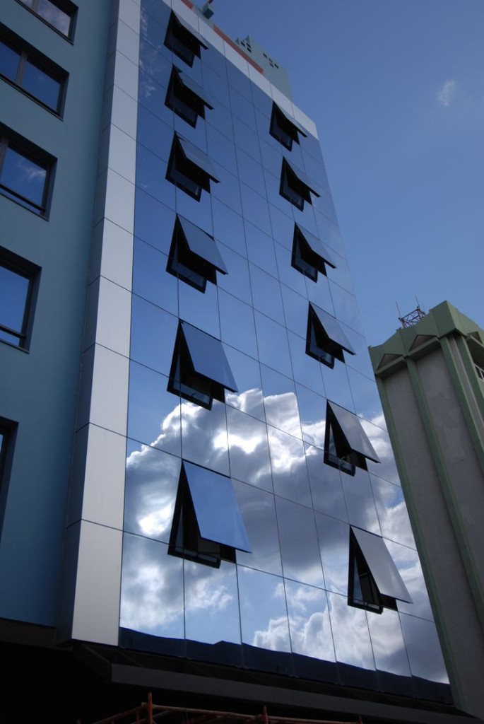 Reflective blue architectural glass curtain wall with open windows