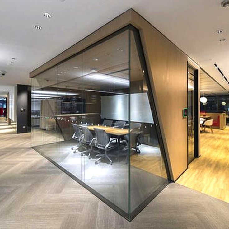 Frameless glass office partitions dividing collaborative workspace