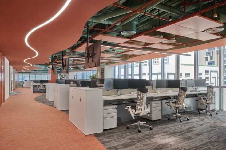Open-plan office with terracotta curved walkway and teal industrial ceiling