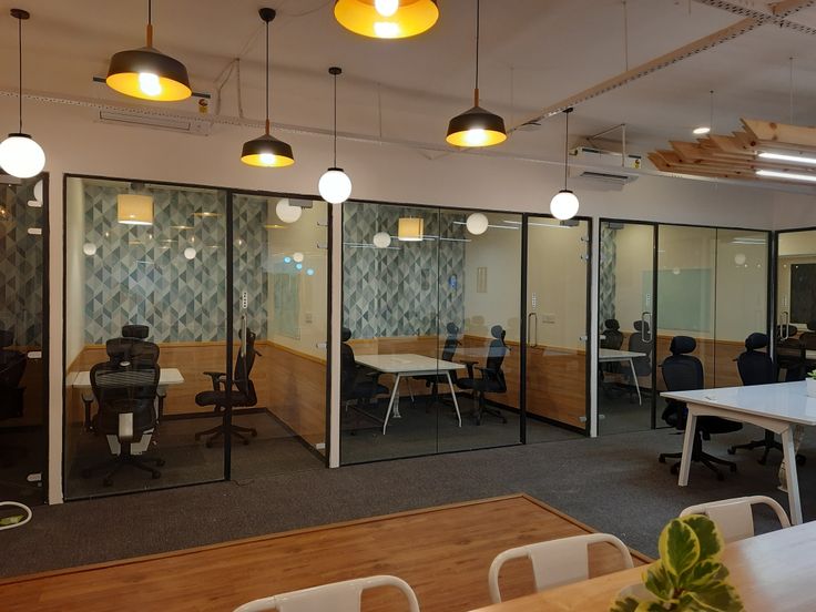 Glass-walled private offices with warm wood and geometric wall panels