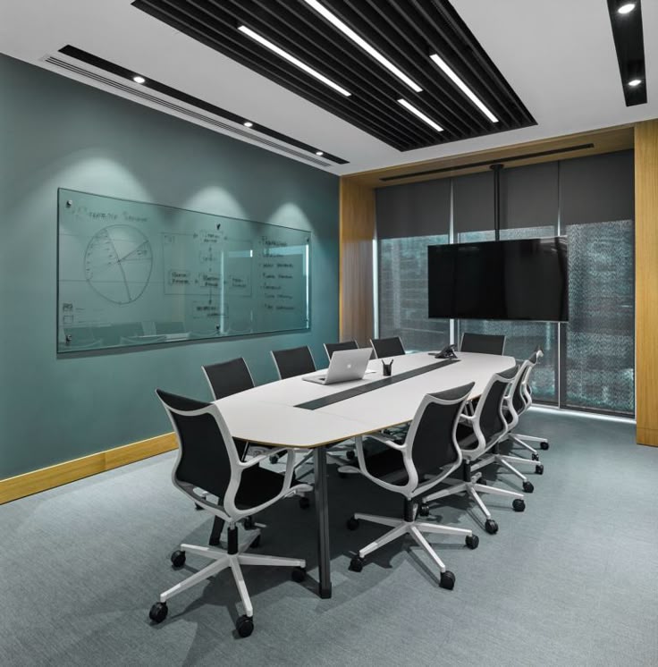 Teal conference room with white table and city view
